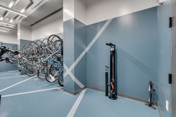 a row of bikes in a room with blue walls and a wall mounted water heater